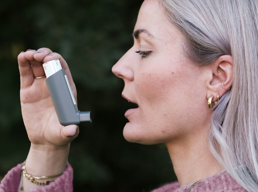 Mujer sosteniendo un inhalador cerca de la boca
